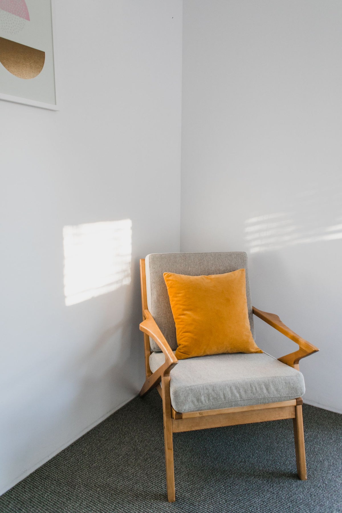 Fauteuil vide avec coussin orange dans un coin lecture cocooning