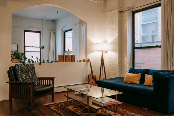 Salon chaleureux avec fauteuil, canapé et grandes fenêtres