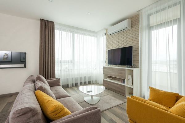 Salon lumineux avec canape, coussins et fauteuil