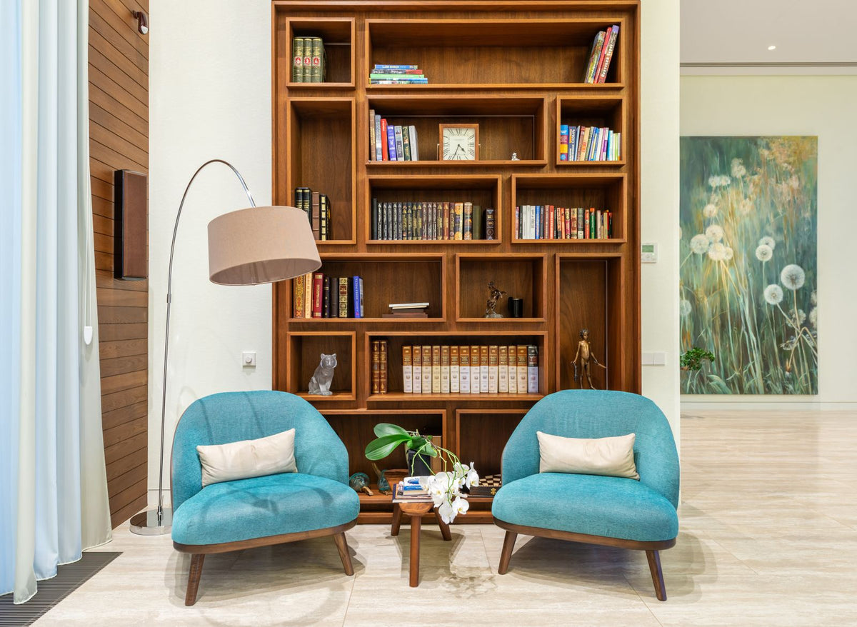 Deux fauteuils confortables près d'une bibliothèque et d'une lampe