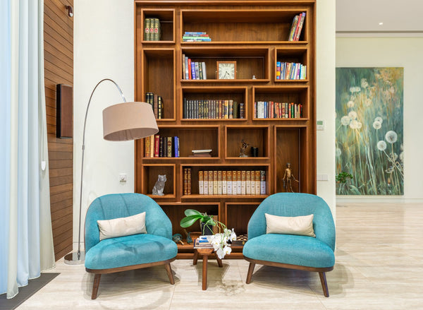 Deux fauteuils confortables près d'une bibliothèque et d'une lampe