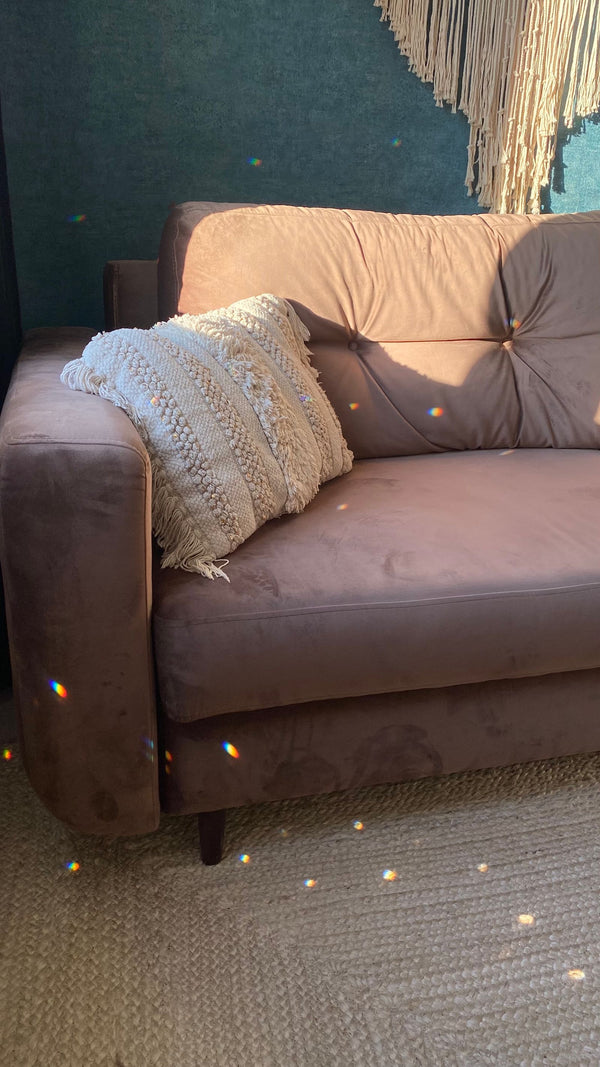 Coussin moelleux pose sur un canape, lumiere douce